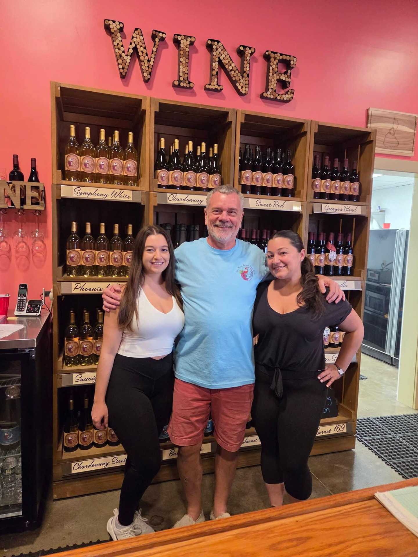 Arnie Schloemann with family in front of the wine wall at Crush Winery